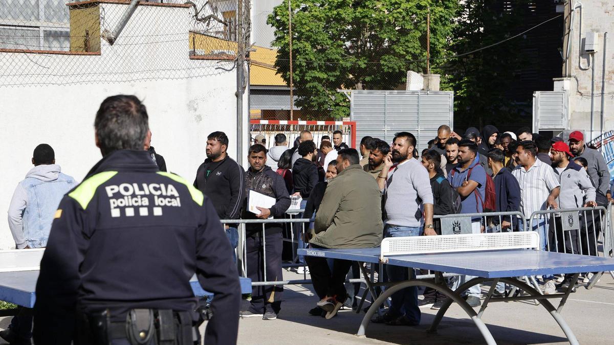 Cues a Salt davant l'oficina que assessora sobre la regularització extraordinària de migrants