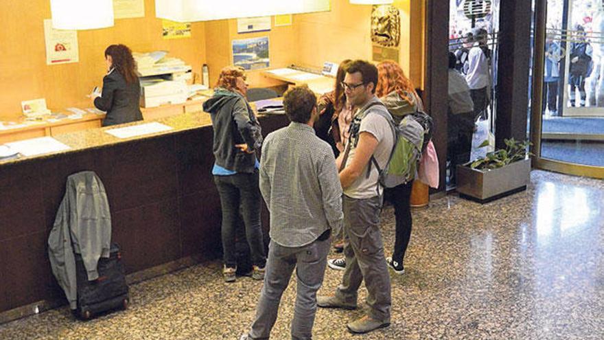 Un grupo de turistas en la recepción de un hotel.