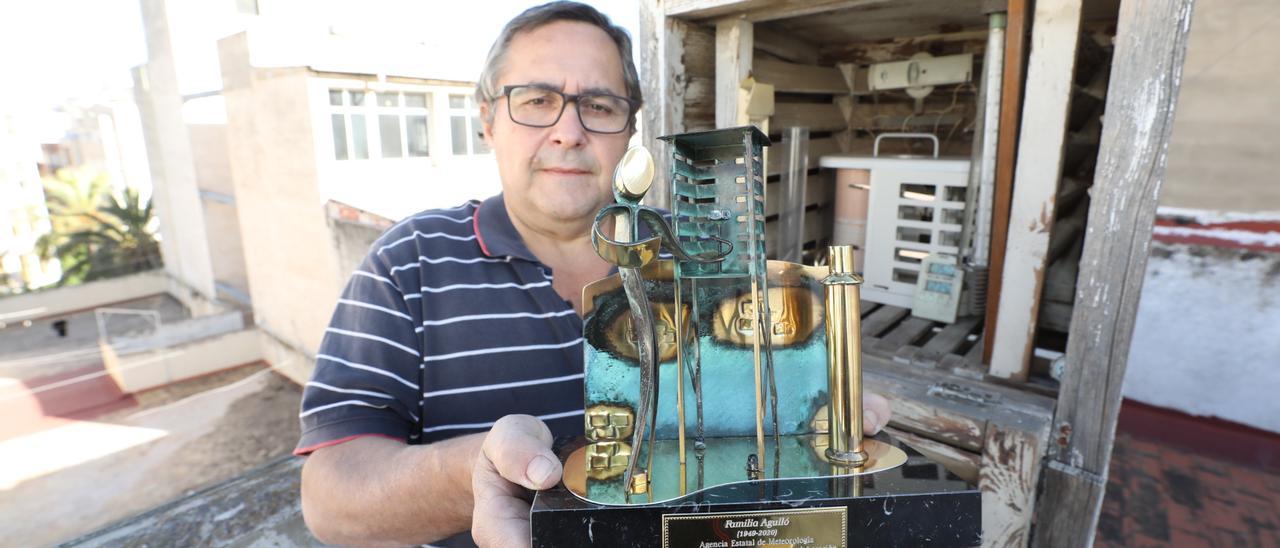 José Agulló, en la estación meteorológica instalada en la terraza de su casa y junto al premio recibido por la AEMET ayer.