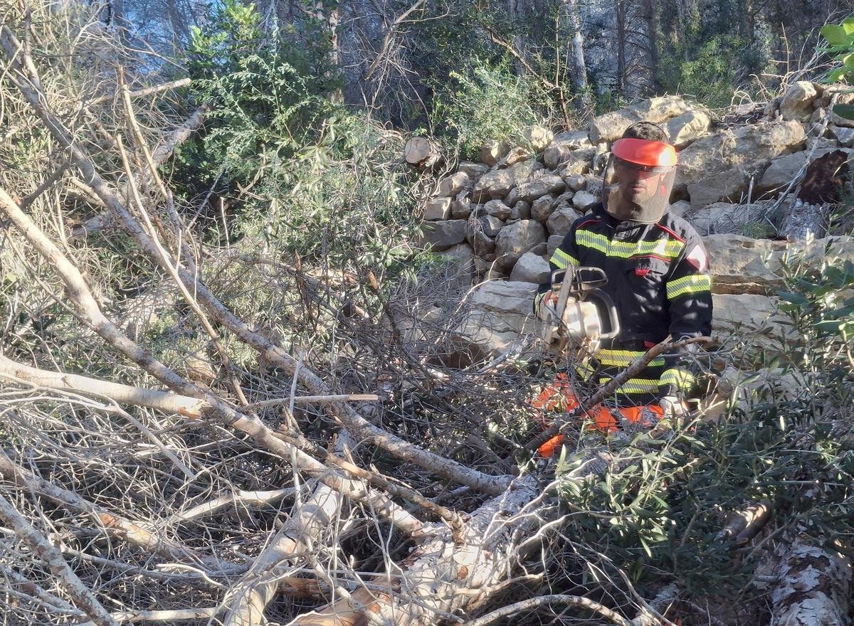 Uno de los bomberos, trabajando en la maraña de ramas secas