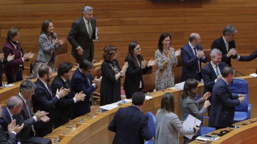 Feijóo, a la derecha, es aplaudido por los diputados del PP con parte de sus conselleiros en primera fila, ayer en el Parlamento. // Xoán Álvarez