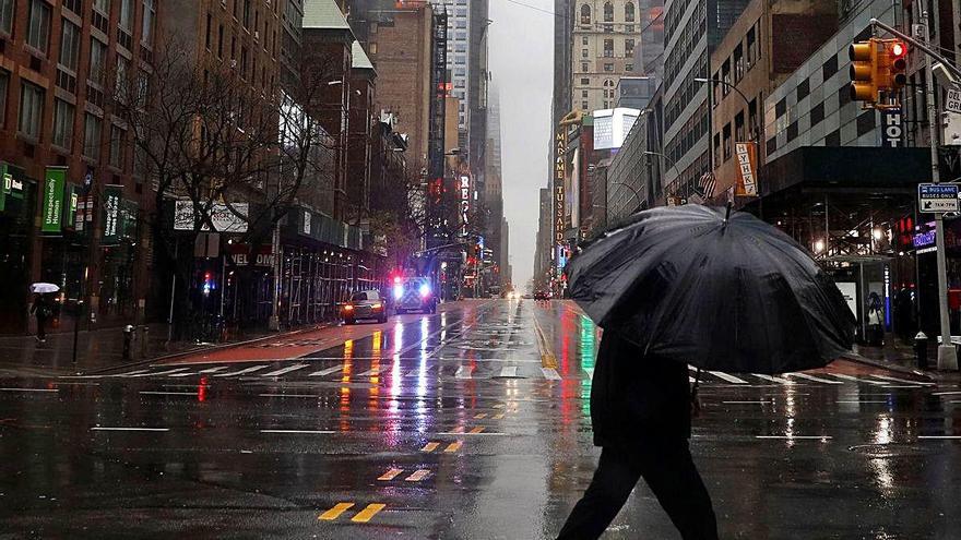 Un hombre cruza bajo la lluvia una calle de Manhattan.