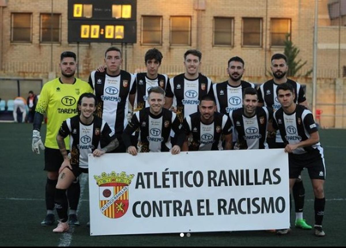 La plantilla del Primera Regional posando en su foto de equipo con un cartel en contra del racismo