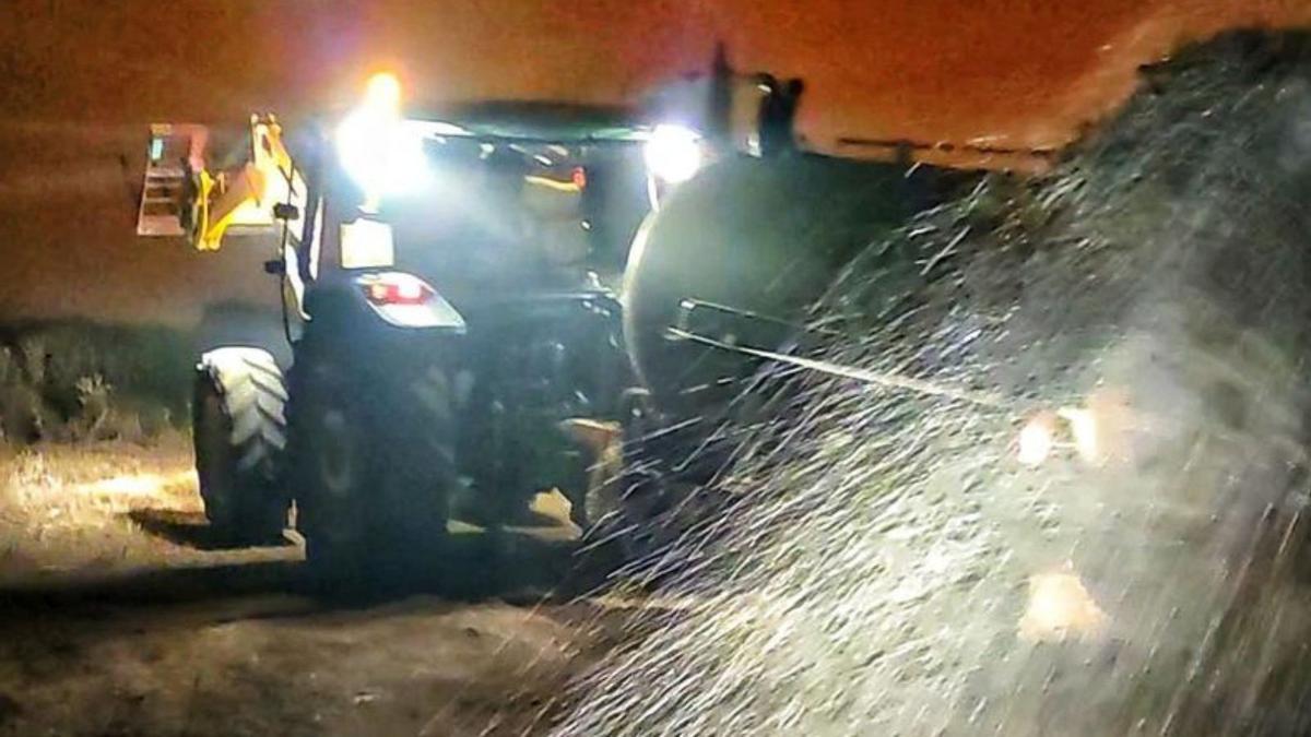 Un tractor esparce agua con la cuba en Carbellino