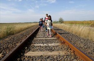 Immigrants sirians caminen per una via després de travessar la frontera entre Hongria i Sèrbia a prop de Roszke.