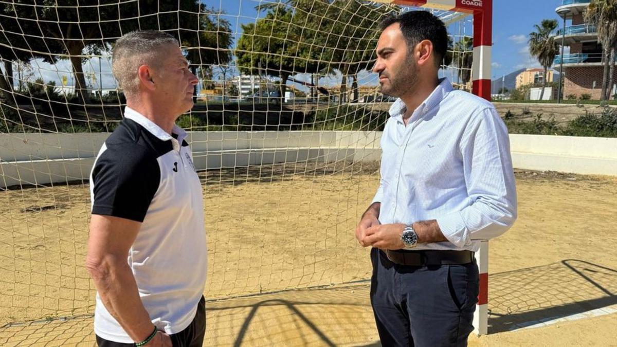 Lisandro Vieytes y Daniel Delgado conversan en una pista de fútbol.