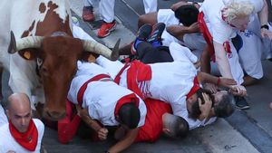 PAMPLONA, 08/07/2025.- Varios corredores caen al paso de uno de los cabestros en el tramo que va desde el final de la cuesta de Santo Domingo a la curva de Mercaderes durante el segundo encierro de los Sanfermines, protagonizado por toros de la ganadería Cebada Gago, este martes, en Pamplona. EFE/ J.P. Urdiroz