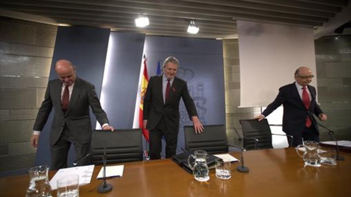 Los ministros Guindos, Méndezde Vigo y Montoro, momentos antes de iniciar la rueda de prensa posterior al Consejo de Ministros de ayer.