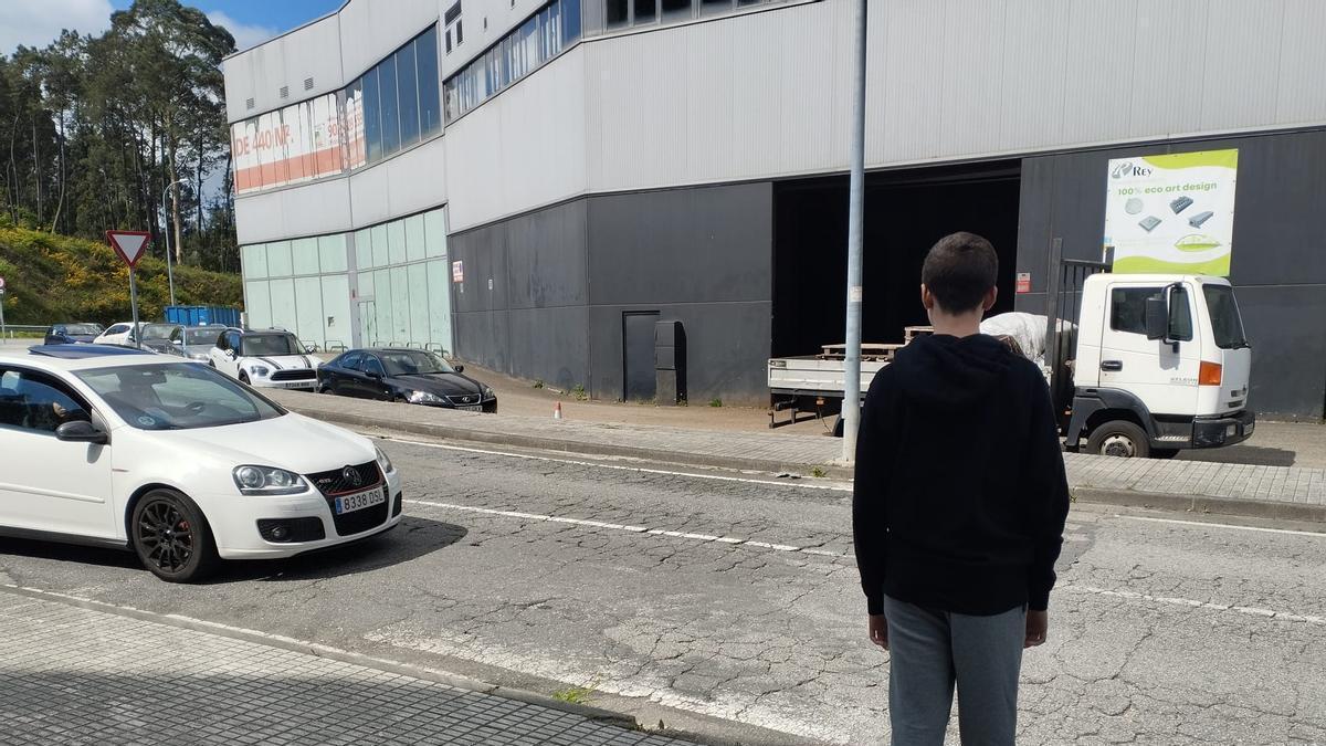 Un niño espera a cruzar la calle en una zona sin paso de peatones próxima al Hospital do Salnés.