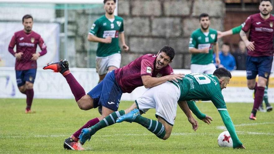 Darío Flores tropieza con un jugador del Coruxo en el partido de ayer en O Vao. // Cristina Graña