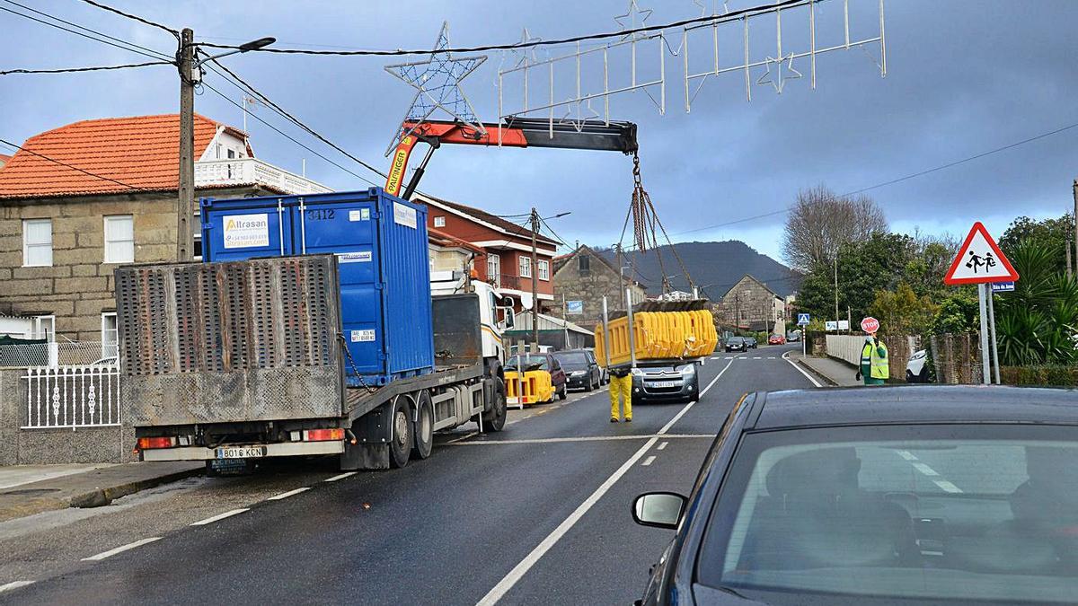 Operarios, esta semana, retirando las vallas tras tapar las zanjas para la tubería en Quintela. |   // G.N.