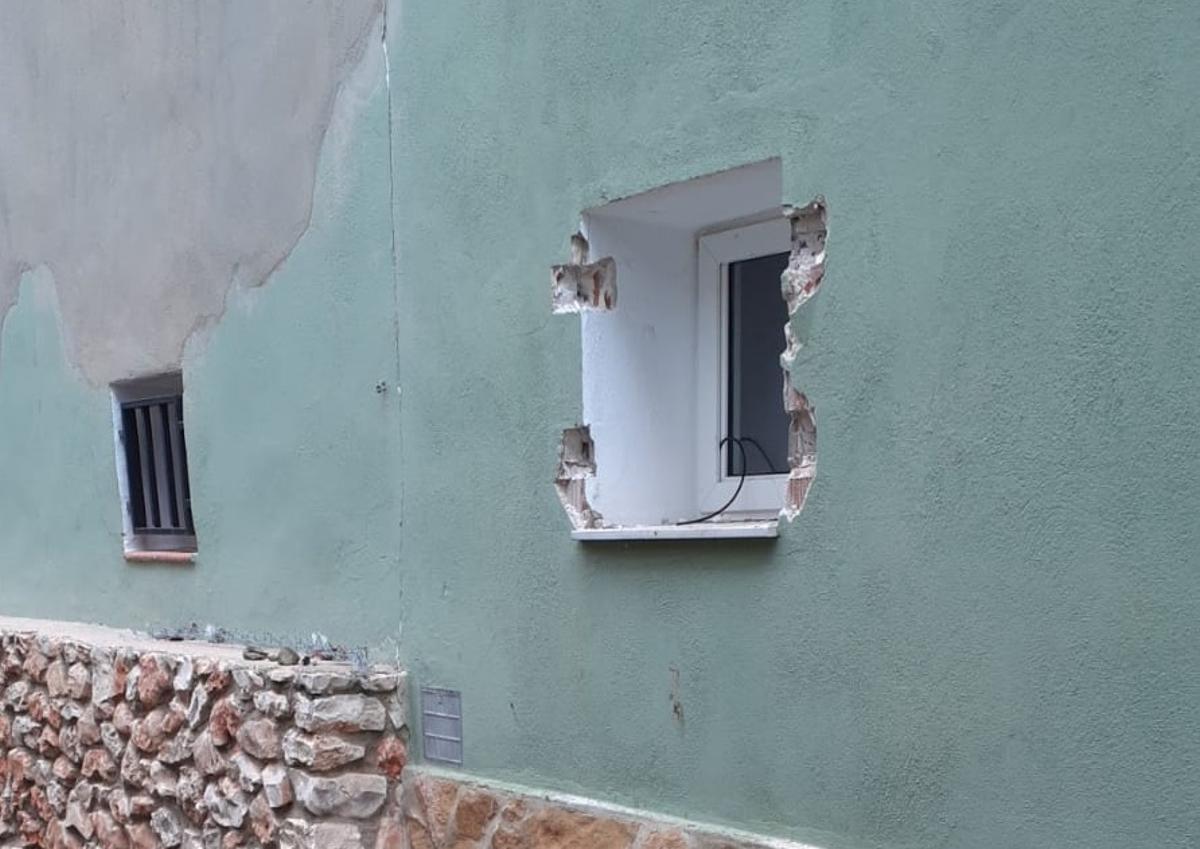 La ventana por la que se colaron los ladrones, tras arrancar la verja de seguridad.