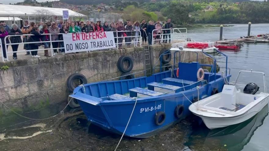 Mariscadoras de Arcade en el puerto ante el barco que las trasladaba a los bancos del fondo de la ría.