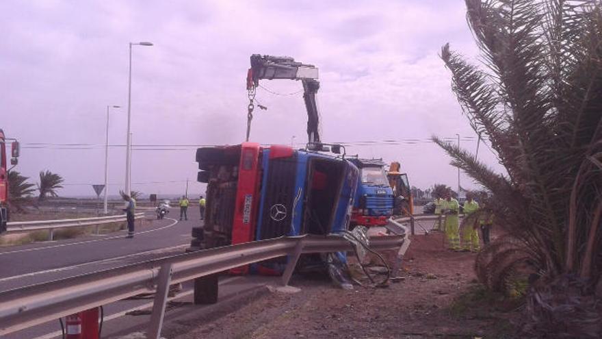 Agentes de la Guardia Civil y de Mantenimiento de Carreteras, junto al camión volcado ayer en Juan Grande.