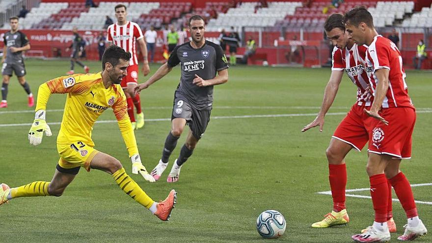 Miquel i Oliván protegeixen una pilota perquè l&#039;agafi Riesgo durant el partit de dimecres contra el Numància a Montilivi, el número 499 al futbol professional del Girona.