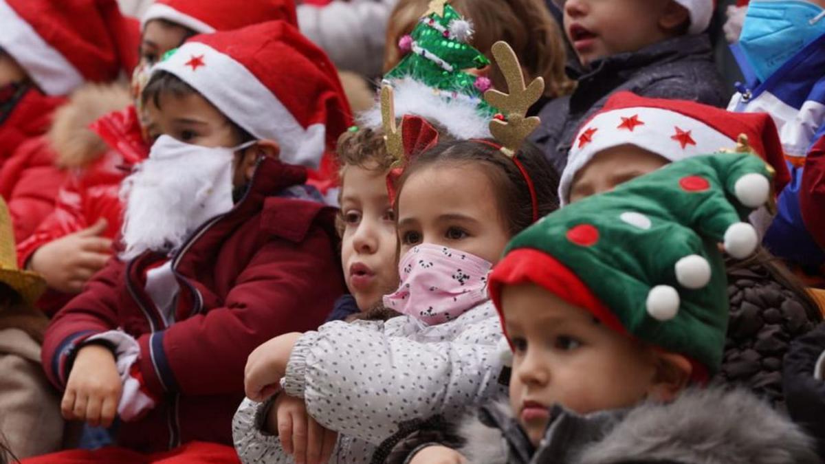 Niños disfrazados con gorros navideños.