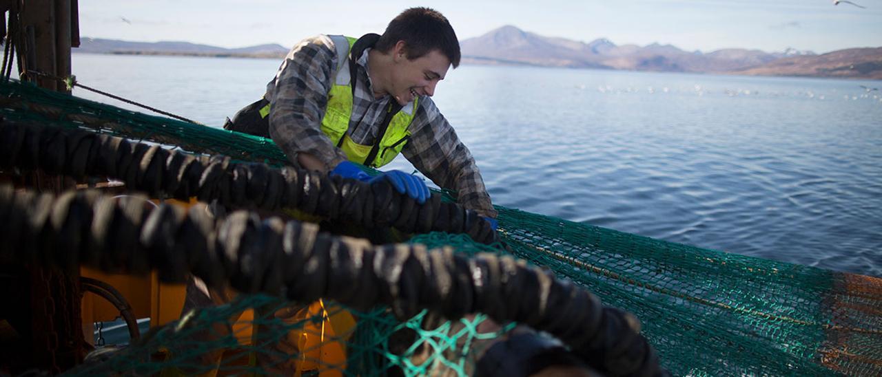 Un pescador joven, recogiendo las redes