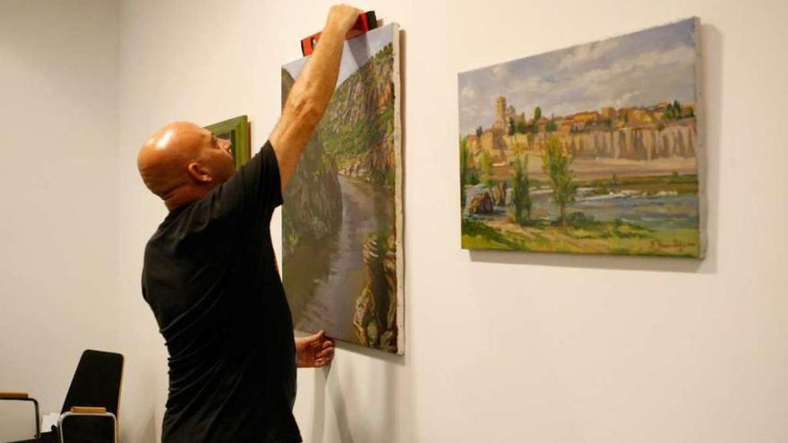 El galerista Ángel Almeida en pleno montaje de la nueva propuesta artística.