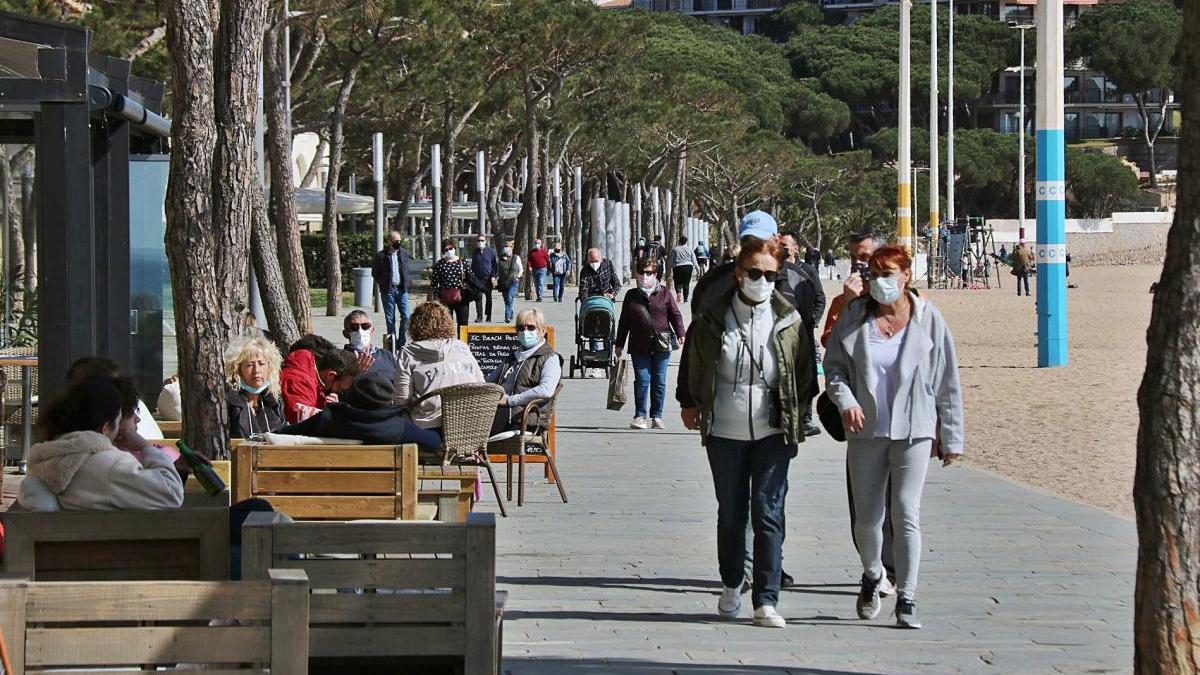 Diverses persones passejant pel passeig Marítim de Platja d&#039;Aro, ahir al migdia.