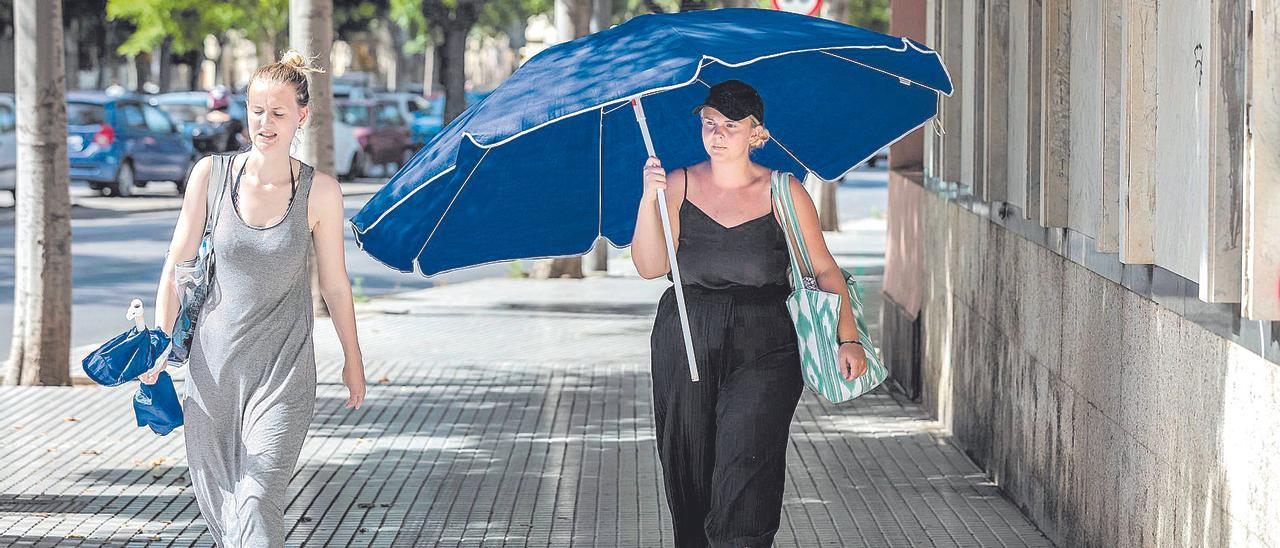 Cualquier medida es buena para protegerse del calor, incluso una sombrilla de playa como improvisado parasol.