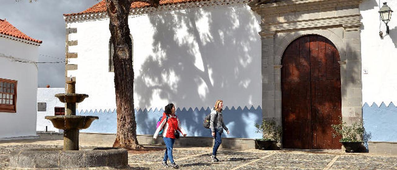 Dos visitantes del barrio histórico artístico, a su paso por la iglesia.