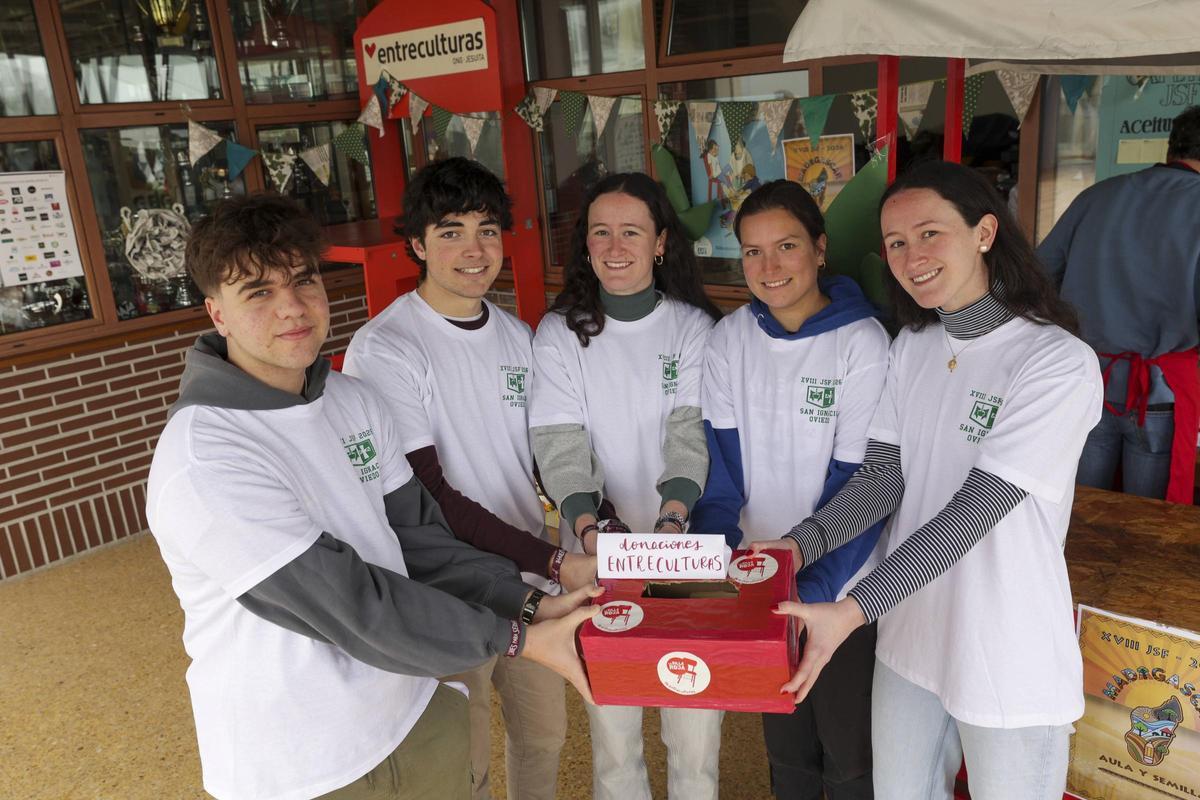 Exalumnos del centro sostienen la caja en la que se depositan los donativos para financiar los dos proyectos.
