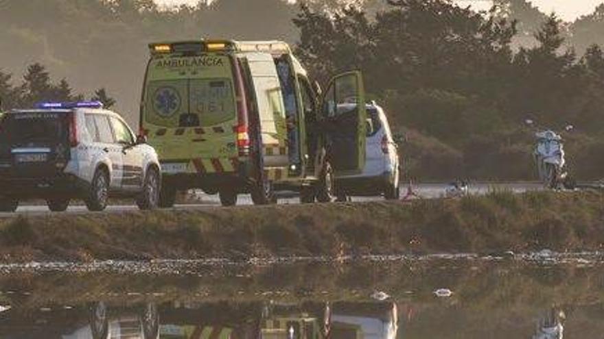 Un vehículo de la Guardia Civil junto al coche y la moto accidentados.