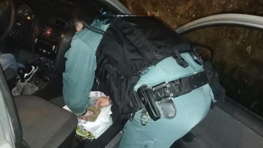 Un agene de la Guardia Civil con la bolsa de marihuana incautada.