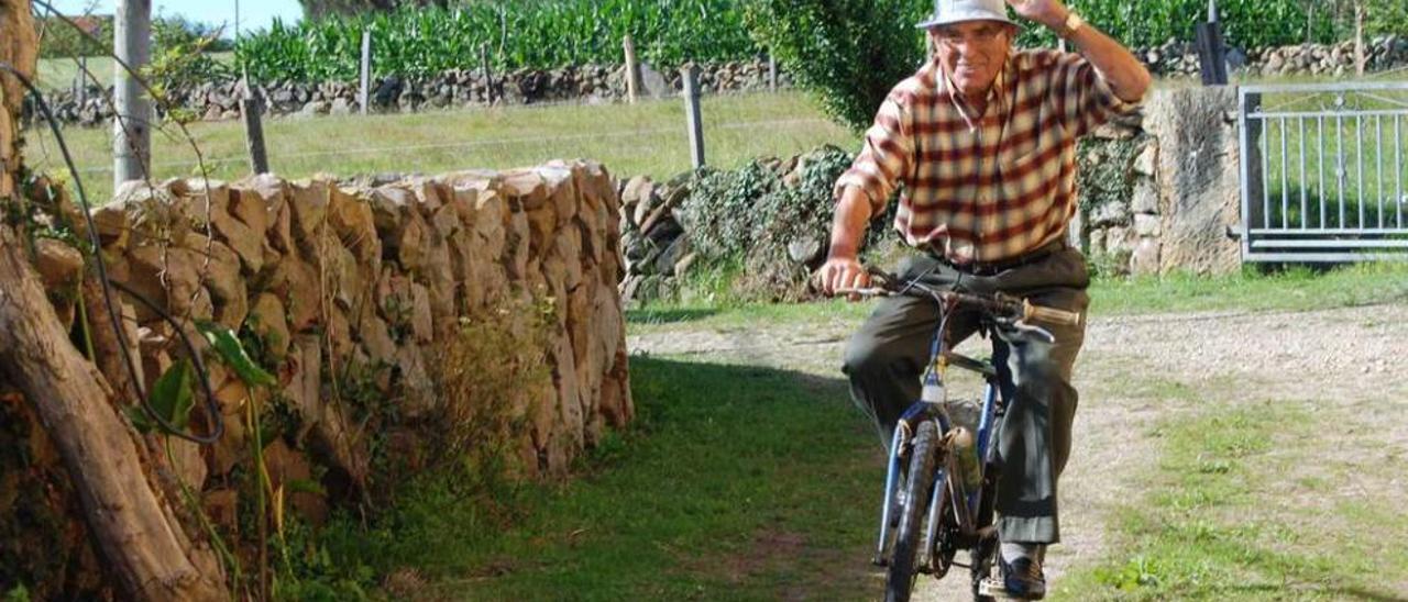 Recaredo Tuero, saludando al mismo tiempo que monta en bicicleta en Argüeru.