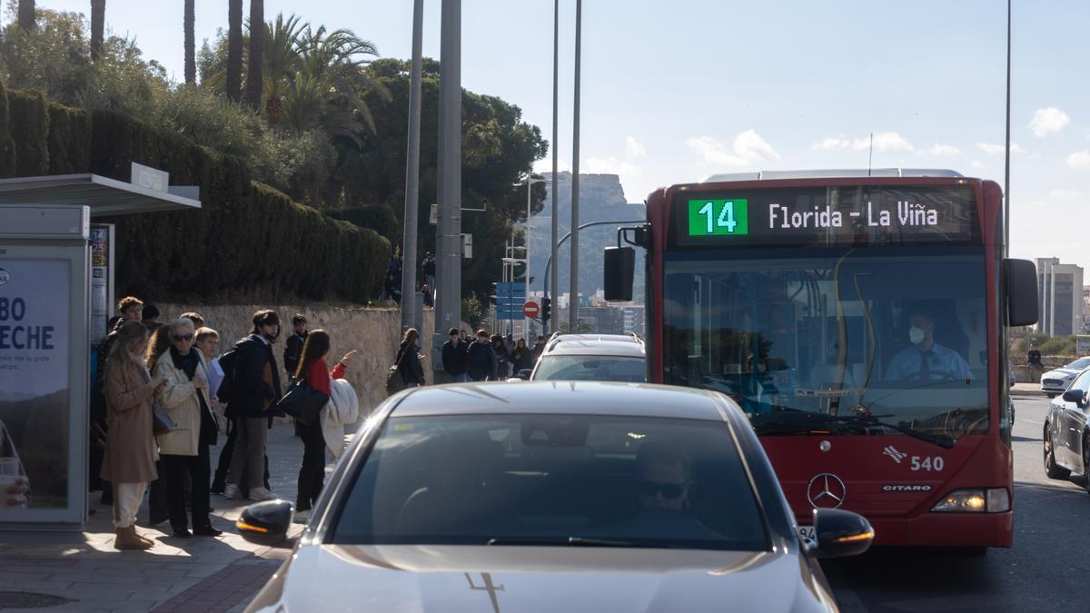 La línea 14 en su parada cabecera, junto a varios coches parados a la espera del colegio.