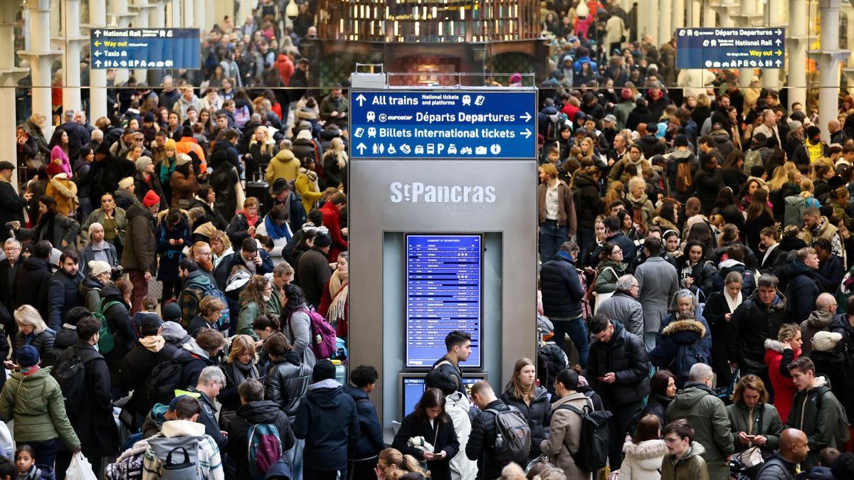 Los pasajeros se acumulan en las puertas de salida de la terminal Eurostar en la estación internacional de St Pancras después de que los servicios se cancelen debido a un túnel inundado, en Londres.