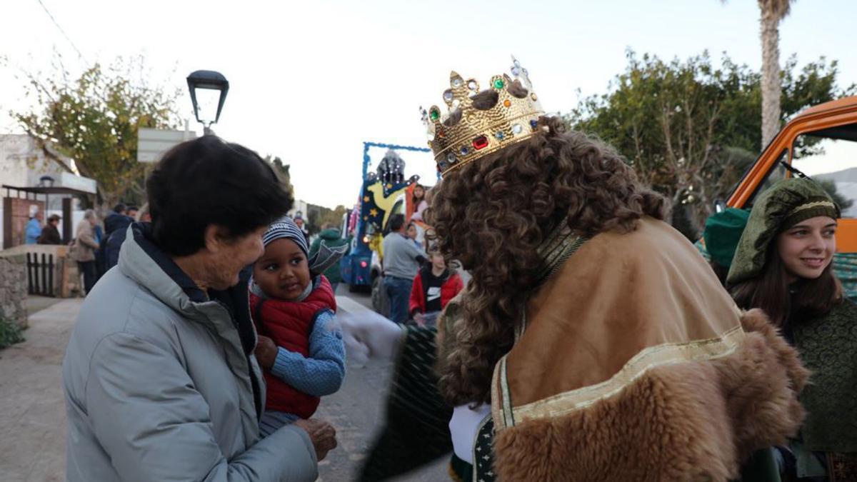 El Rey Gaspar se acerca a una niña con su abuela para saludarla en la Mola.