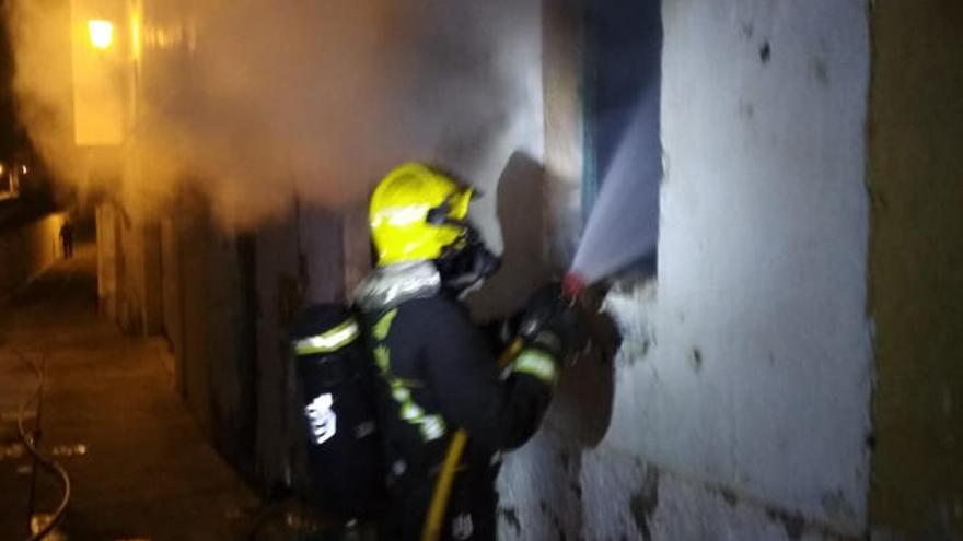 Un bombero intenta sofocar el incendio en la casa cueva de Manolo &#039;el Guanche&#039;.