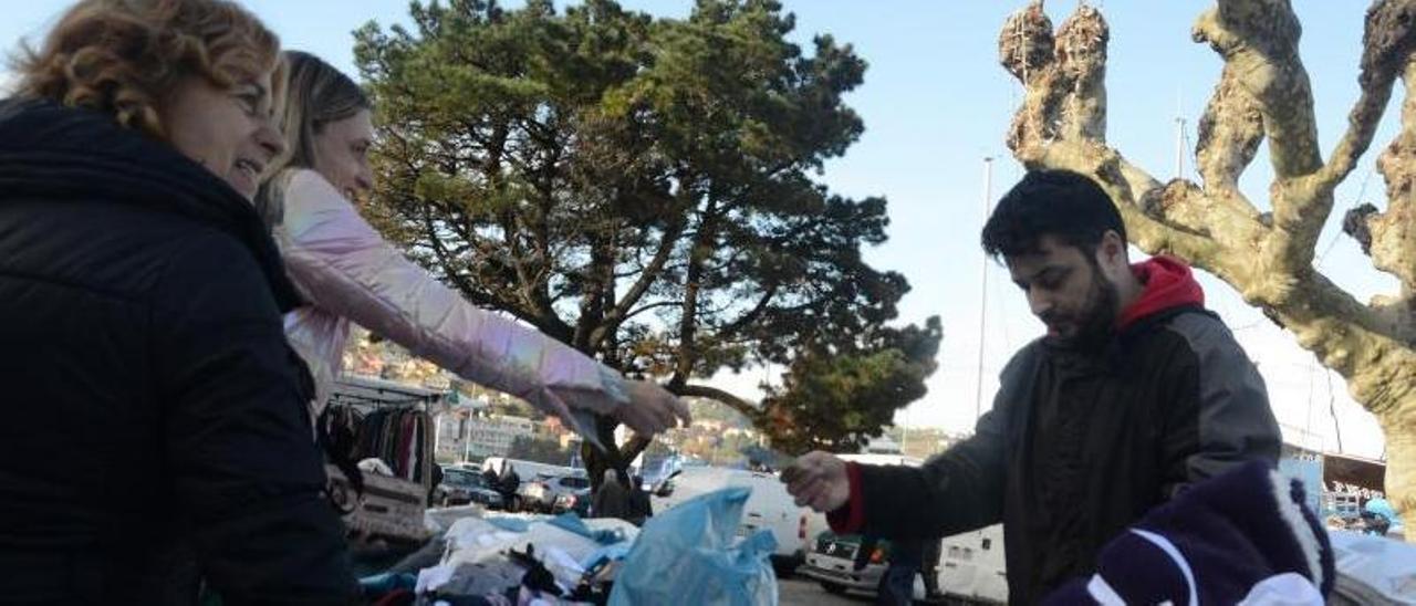 Unas clientas pagan ayer una compra en uno de los puestos del mercadillo de Bueu.   | // GONZALO NÚÑEZ