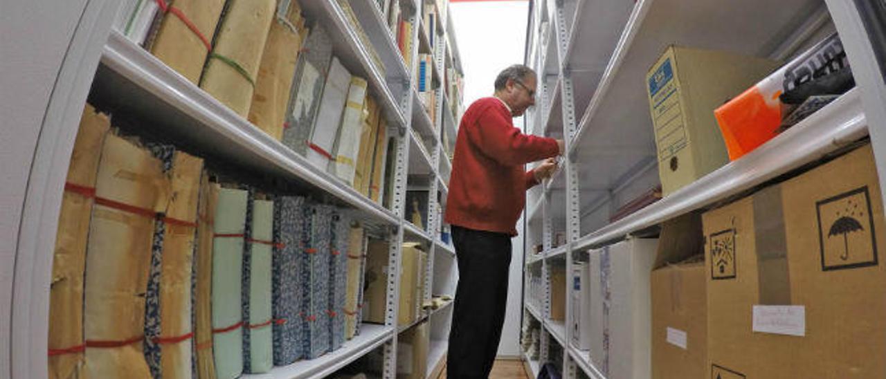 El archivero municipal revisa cajas de documentos.