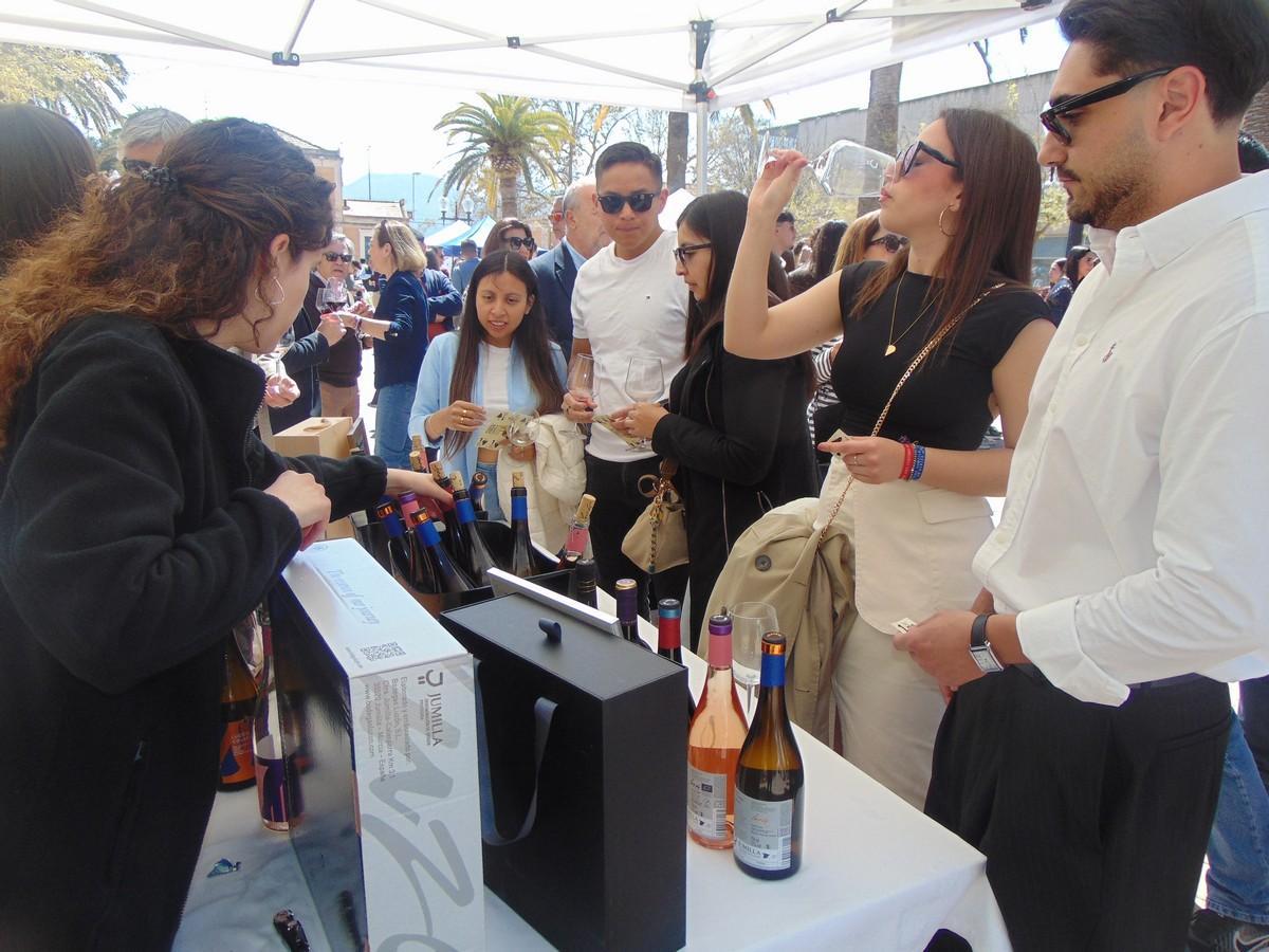 Un grupo de epersonas prueba vino en una feria.