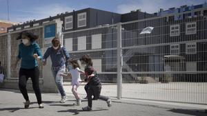 Un grupo de niños juegan en la puerta de una escuela del Poblenou, en mayo.