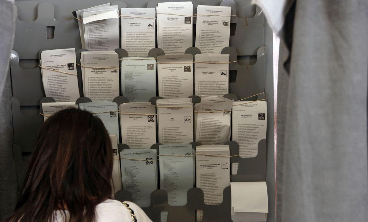 Una mujer busca su papeleta en las elecciones municipales de 2019. | ÁLEX ZEA