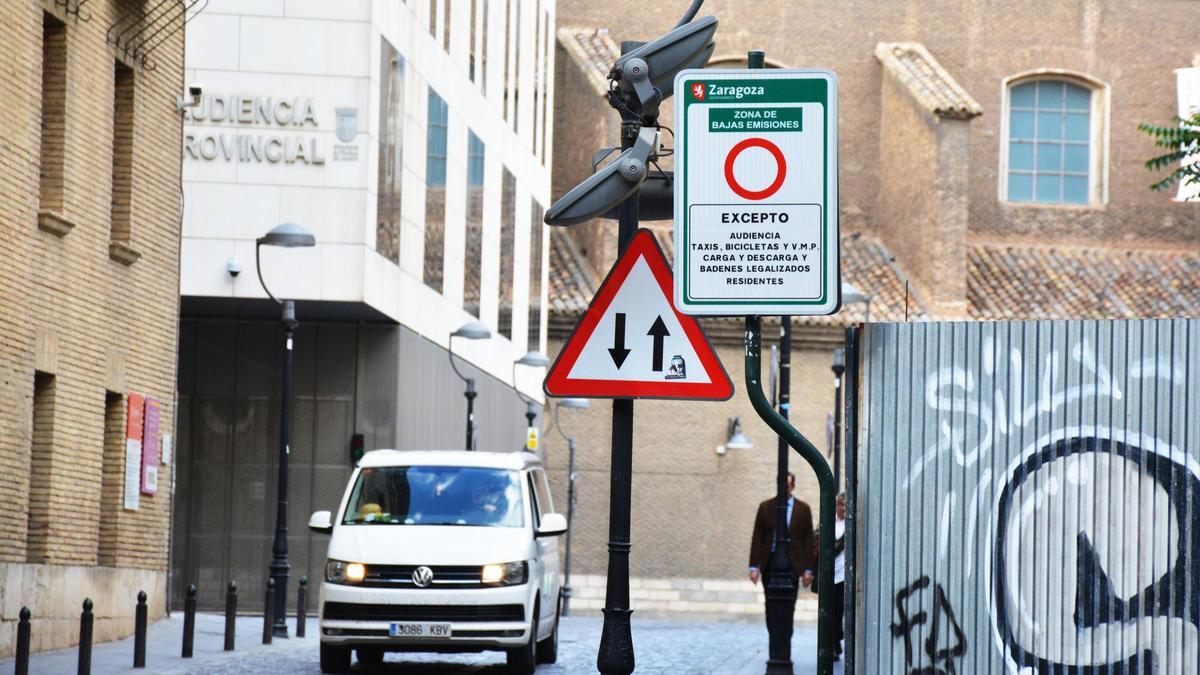 Una furgoneta circula por la calle Galo Ponte, en el Casco Histórico de Zaragoza, donde un cartel anuncia la Zona de Bajas Emisiones.