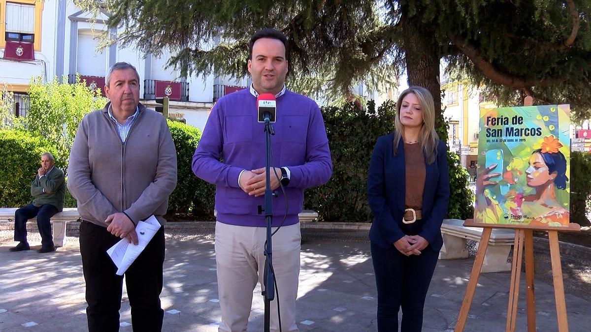 Antonio Navas, Juan Ramón Valdivia y Eva Gómez, junto al cartel de la feria de San Marcos.