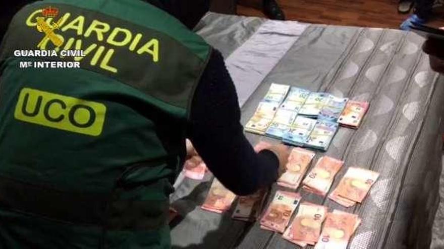 Un agente, con el dinero incautado a la banda.