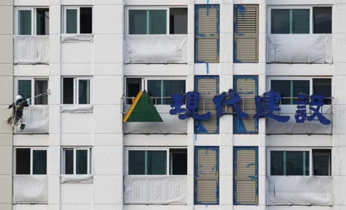 Un operari treballa a la façana de Hyundai Enginyeria i Construcció a Seül (Corea del Sud).