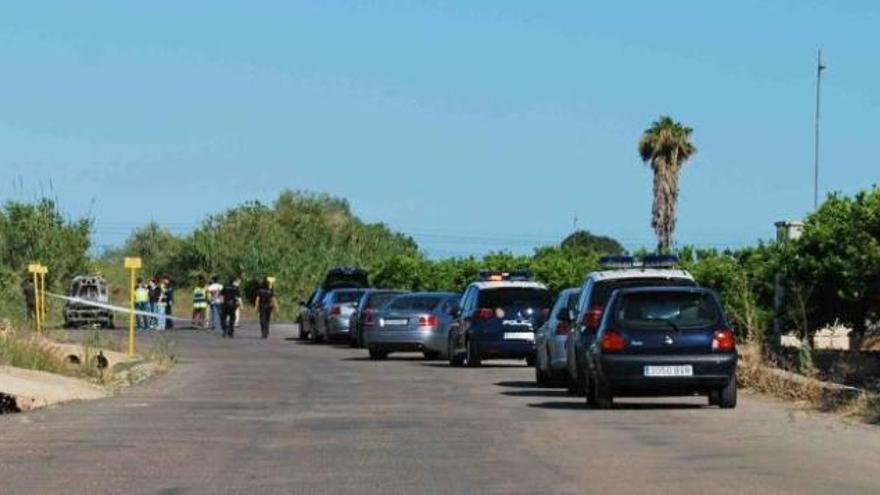 La Policia Nacional inspecciona el vehículo, poco antes del levantamiento del cadáver.