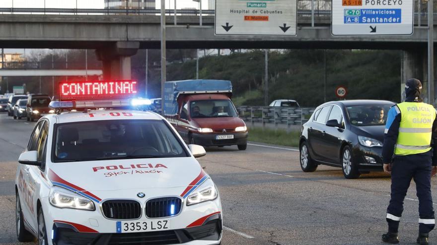 Aviso en un coche policial de una restricción del tráfico por contaminación en la avenida del Príncipe de Asturias.