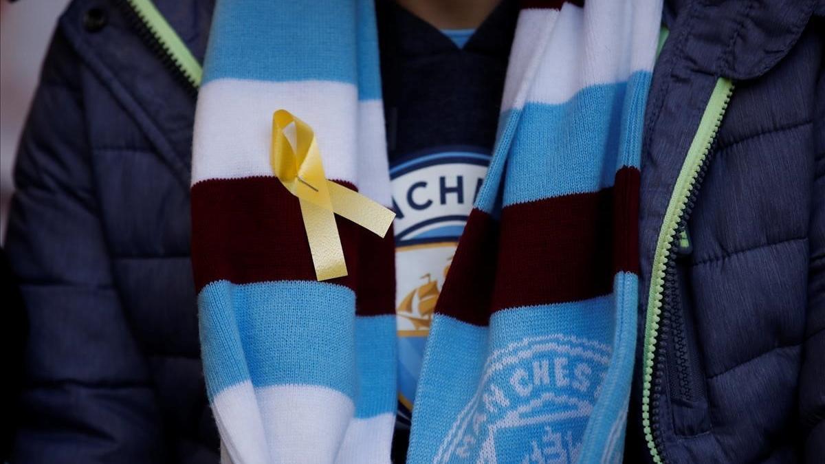 Un aficionado del City luce en su bufanda un lazo amarillo antes de la final de Wembley