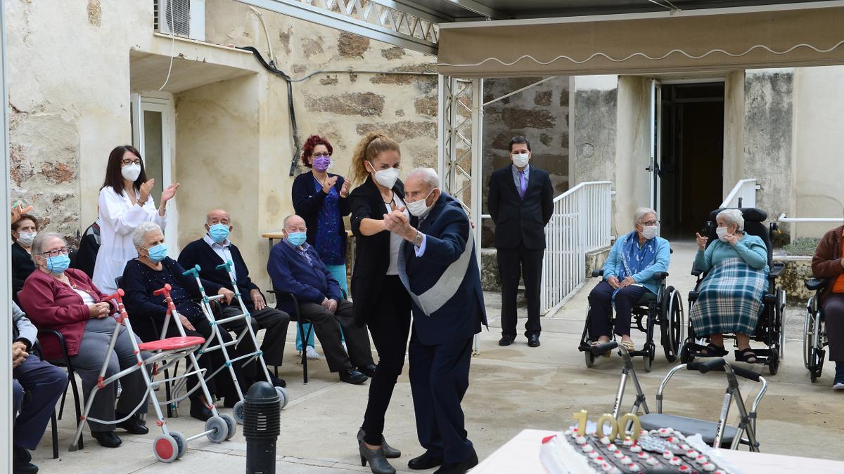 Julián y la directora de la residencia, bailando ante sus compañeros y su tarta.