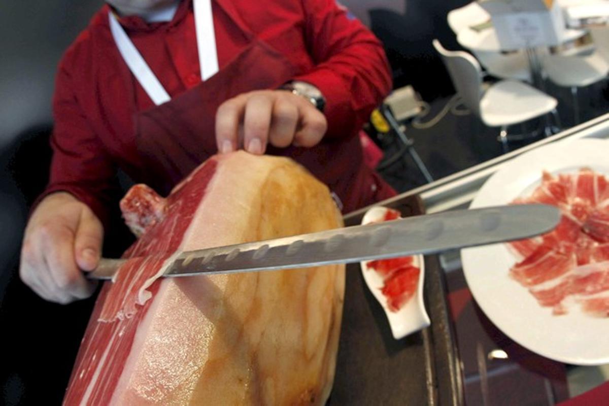 Un hombre corta jamón. Un hombre corta jamón.