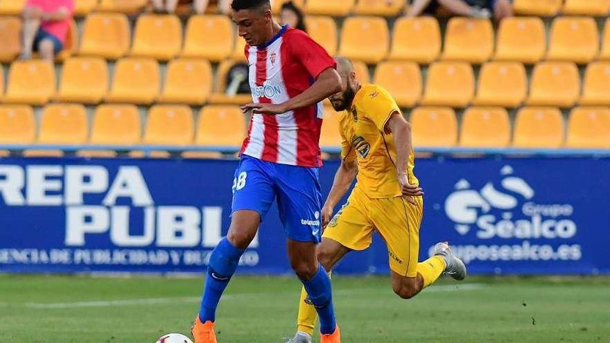 Pablo Fernández, del Sporting, protege el balón ante el exdeportivista Laure ayer en Alcorcón.