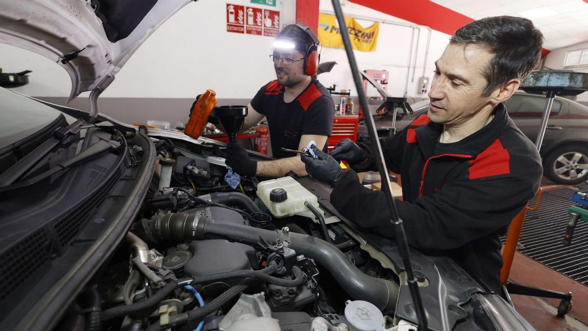 Raúl Mesías y su empleado, en el taller Autobox de O Burgo. | Gustavo Santos