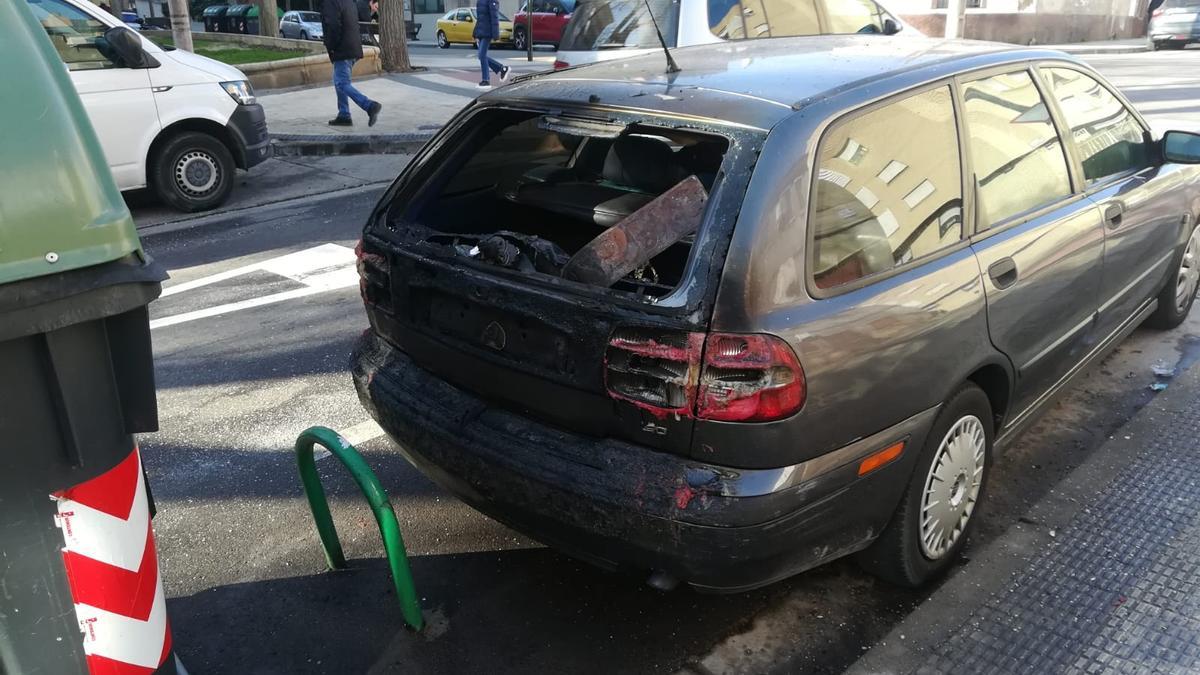 Un coche afectado por la quema de contenedores en la calle Coronel Moyano.